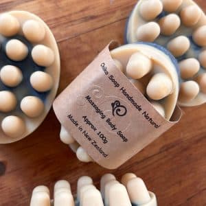 血行促進とリラックス効果をもたらす丸みを帯びた突起が特徴の手作りボディマッサージソープ、木製のトレイに置かれています。